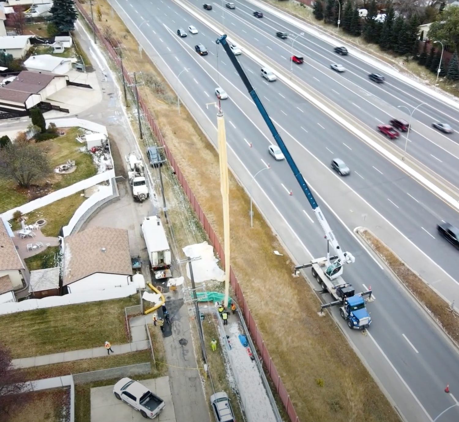A crane setting a Triplex Liner over a live highway, from the air